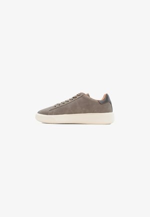 Zapatillas de ante gris con suela de goma blanca, con un diseño de corte bajo, punta redonda y seis ojales para cordones. Acento de cuero en el talón.