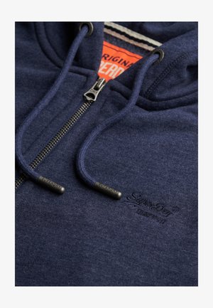 Marineblauwe ritshoodie met trekkoorden, metalen ritssluiting en subtiel geborduurd "Superdry" logo op de borst, met een oranje binnenlabel.