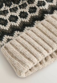 Knitted wool beanie featuring a geometric pattern in black and beige, with a textured ribbed cuff in a lighter beige color.