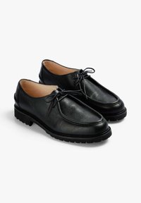 Zapatos de cuero negro con un acabado texturizado, puntera redonda y diseño de cordones. Cuentan con una suela robusta para mayor agarre y un tacón bajo.