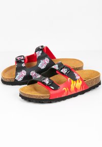 Sandales noires et rouges avec deux brides réglables, semelle en liège et motif de flamme sur le côté rouge ; présente des graphismes de véhicules en jouet sur le noir.