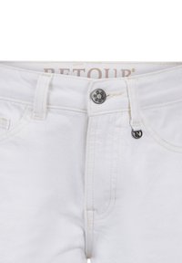 Weiße Denim-Jeans mit sichtbaren Nähten, einem metallischen Knopfverschluss und einem kleinen Markenetikett am Bund. Sauberes Design, kein Muster.