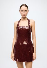 Burgundy sequin mini dress with halter neckline, fitted bodice, and flared skirt, featuring a smooth texture and shimmering surface.