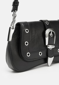 Schwarze Kunstledertasche mit strukturierter Form, ausgestattet mit silbernem Beschlag, runden Nieten und einem großen Schnallendetail auf der Klappe.