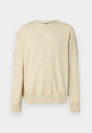 Sudadera beige con mangas largas, puños acanalados y cuello redondo. Presenta un pequeño logo blanco en el pecho. Textura suave.