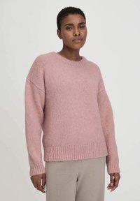 Helles rosa gestricktes Sweatshirt mit rundem Halsausschnitt, überschnittenen Schultern und geripptem Saum. Weiche Textur, lässige Passform und lange Ärmel.