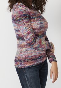 Pull en tricot multicolore avec un design texturé et des rayures roses, bleues et jaunes. Manches longues et coupe ajustée.