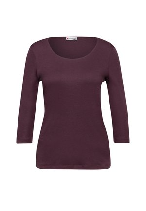 Top bordeaux a maniche lunghe con scollo ampio, texture morbida e silhouette aderente. Rifinito con un orlo che scende sotto i fianchi.