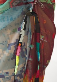 Multicolored sheer fabric with pixel-like patterns. Features a gathered design, contrasting edges in vibrant hues, and a smooth texture.