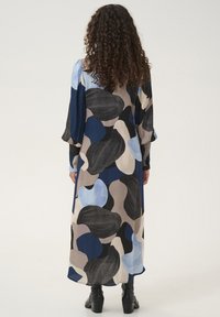 Long dress featuring an abstract pattern in blue, black, and beige tones; made of lightweight fabric with puffed sleeves and a flowing silhouette.