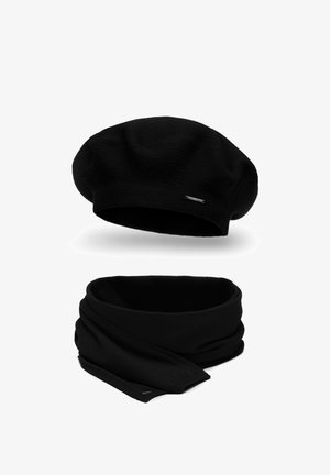 Zwarte gebreide baret met een gestructureerd oppervlak en een kleine logo-accent, gecombineerd met een bijpassende zwarte sjaal in een glad, gelusht ontwerp.