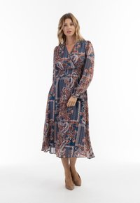 Rochie lungă, transparentă, cu un model paisley în nuanțe de albastru și maro, având mâneci lungi, decolteu adânc în V și talie elastică.