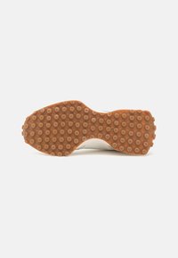 Suela de zapato de caucho marrón con patrón de banda de rodadura circular; forma plana y ligeramente contorneada, diseñada para tracción y estabilidad.