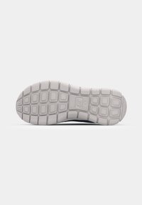 Shoe with a textured, white rubber outsole featuring a grid pattern. The sole shows durability and traction design elements.