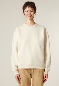 Sweatshirt color crema con una vestibilità rilassata, scollatura tonda a coste e polsini. Tessuto morbido e design minimalista senza loghi visibili.