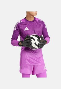 Paarse doeltjestrui met een verloopontwerp, bijpassende shorts en zwarte handschoenen die een zwart-witte voetbals bal vasthouden. adidas-logo zichtbaar.