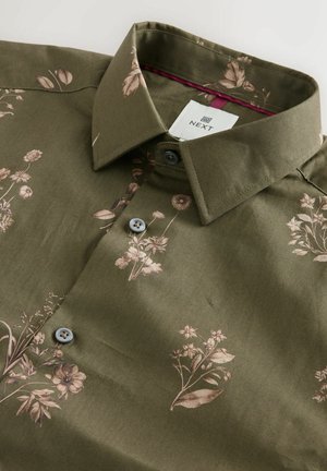 Olive green button-up shirt with beige floral print, spread collar, and brand label "NEXT" inside the collar.
