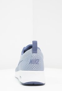 Nike-Sneaker in Hellblau und Grau. Obermaterial aus Mesh mit Belüftungsöffnungen, weicher Fersenlasche, weiße Zwischensohle. Verfügt über ein strukturiertes Logo auf der Rückseite.