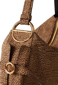 Borsa a tracolla marrone con una finitura testurizzata e un accento in metallo dorato a forma di cerchio, dotata di una zip. Presenta una tracolla con dettagli testurizzati coordinati.