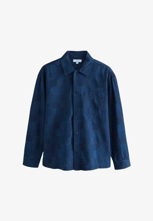 Sötétkék, gombos ing foltmintás kialakítással, klasszikus gallérral, hosszú ujjakkal és mellzsebbel. Puha tapintású anyag.