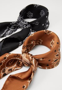 Zwei gemusterte Schals: einer schwarz mit weißen Paisley-Mustern und einer braun mit komplizierten orangefarbenen und schwarzen Mustern, beide aus glänzendem Stoff.