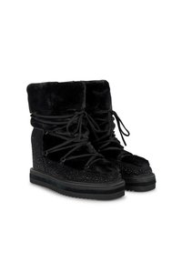 Botas de caña alta negras con parte superior de pelo sintético, detalles texturizados y una media suela con tachuelas; cuenta con un diseño de cordones y una suela de goma gruesa.