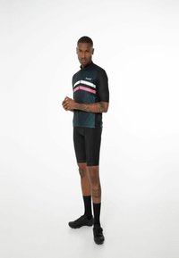 Krátký rukáv cyklistický dres v tmavě modré barvě s bílými, růžovými a černými pruhy; v kombinaci s černými šortkami a cyklistickými botami, má zip na přední straně.