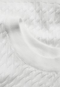 Witte gebreide trui met kabelpatroon, geribbelde kraag en zachte textuur. Het ontwerp is eenvoudig en elegant met een schone, monochrome uitstraling.