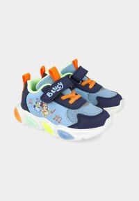 Zapatillas deportivas azules con una mezcla de materiales marino y azul claro, con detalles en naranja, correa de velcro, textura de malla y suelas coloridas que iluminan.