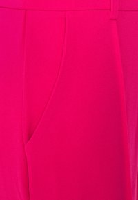 Pantaloni fucsia caratterizzati da una texture liscia, tasche laterali e una vestibilità su misura. Includono pieghe sottili per un tocco di dettaglio in più.