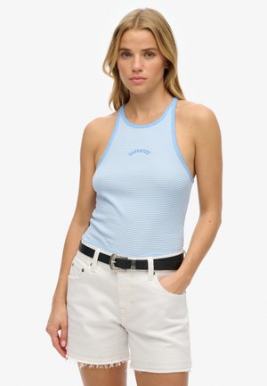 Niebieska i biała w paski, prążkowana bluzka na ramiączkach z dekoltem halter; noszona z białymi szortami dżinsowymi z postrzępionymi brzegami i czarnym paskiem.