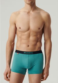 Turkusowe bokserki męskie z czarnym elastycznym pasem z nazwą marki "ATLANTIC" w jasnoniebieskim kolorze. Miękki, elastyczny materiał.
