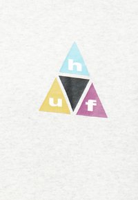 Tre triangoli colorati disposti a formare un triangolo più grande con le lettere "h," "u" e "f" su uno sfondo di tessuto bianco.