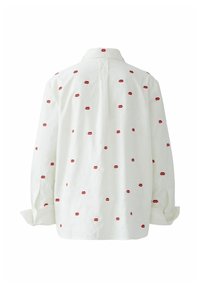 White cotton shirt featuring a repeated red lip print, with a collared neck, long sleeves, and a relaxed fit. Back design includes a center seam.