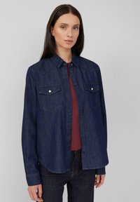 Dunkelblauses Denim-Hemd mit durchgehender Knopfleiste, spitzem Kragen, zwei Brusttaschen und metallischen Knöpfen. Verfügt über einen geraden Schnitt und lange Ärmel.