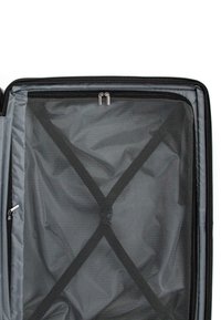 Interno di una valigia nera con rivestimento in rete grigia, cerniere e cinghie elastiche incrociate per fissare il contenuto. Texture liscia e design strutturato.