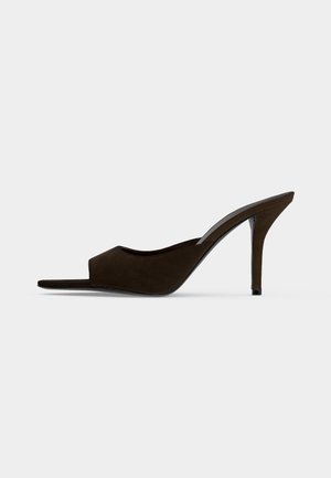 Mule en daim noir à bout ouvert, talon haut et fin, design slip-on, vue de profil sur un fond uni.
