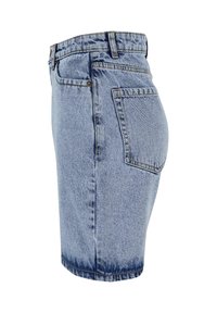 Light blue denim skirt with high waist, side seam, and back pocket, shown from the side on a white background.