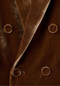 Blazer croisé en velours marron avec quatre grands boutons recouverts du même tissu et col à revers plié.