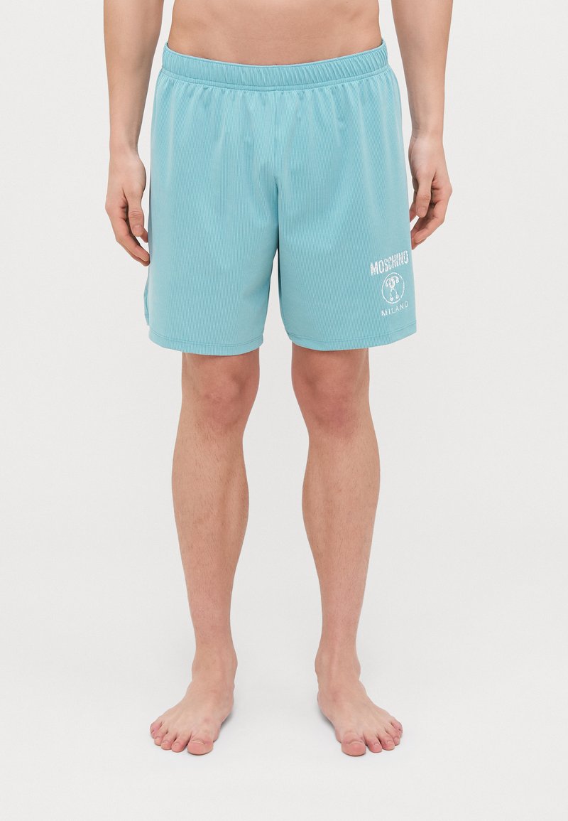 Svetlomodré plavky s textúrovaným vzorom, elastickým pásom a bielym logom Moschino na ľavom stehne.