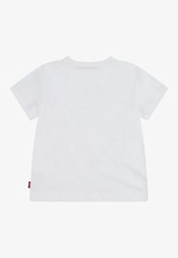 Valge puuvillane T-särk lühikeste varrukatega, ümmarguse kaelusega ja väikese punase etiketi vasaku alumise külje peal. Sile, ühtlane tekstuur.