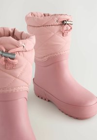 Stivali impermeabili rosa con un motivo trapuntato sulla tomaia, parte superiore elastica e suole in gomma textrurizzata per una buona aderenza e stabilità.