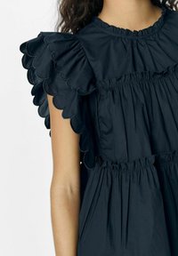 Navy Kleid mit geschwungenen Ärmeln, gerafftem Oberteil und strukturiertem Stoff. Das Design umfasst Rüschenakzente und einen elastischen Taillendetail.
