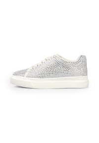 Zapatilla baja blanca con cordones blancos, cubierta de brillantes plateados y una gruesa suela de goma blanca.