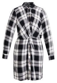 Abito a camicia a scacchi in bianco e nero, maniche lunghe, colletto, chiusura con bottoni, dettaglio vita annodata, tessuto morbido, design casual.