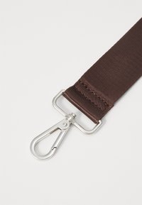 Brown fabric strap with a textured surface, featuring a silver metal clip attached. The strap has reinforced stitching at the edges.