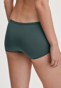 Donkergroene katoenmixboxers met een gladde textuur en een low-rise tailleband, met een strakke pasvorm en geen zichtbare naden.