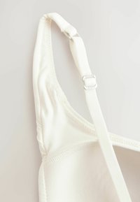 Witte zachte stof bh-band met verstelbare zilveren metalen slider, met een naadloos ontwerp en een gladde textuur voor comfort.