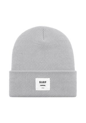 Dziecko noszące szarą czapkę i białą koszulę niesie deskorolkę z kolorową grafiką na ulicy miasta.