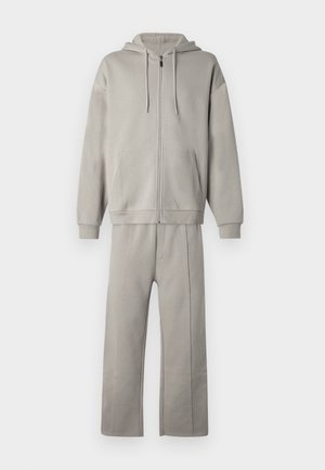 Lysegrå unisex to-delt treningsdress med hettejakke med glidelås og bukser med vide ben, med frontlommer og snorer på hetten.